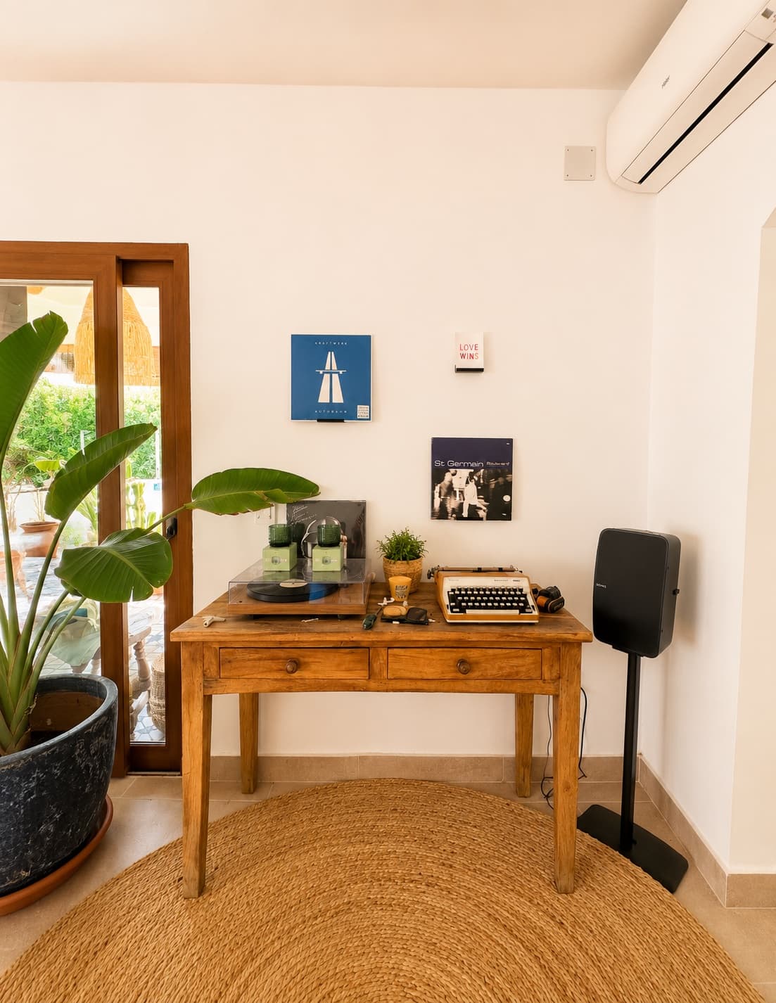 A wooden desk with a turntable, a typewriter and Kraftwerk on the wall: records instead of televisions